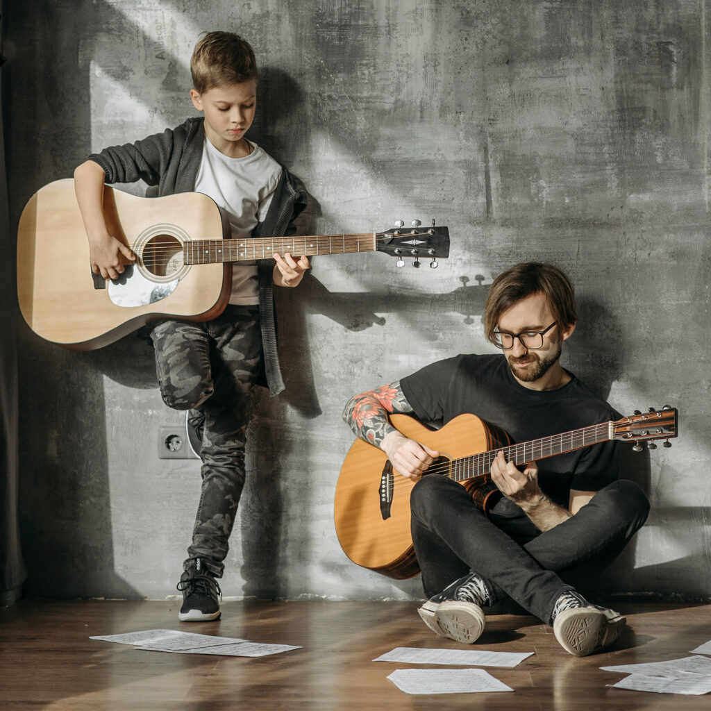 father and son playing the guitar